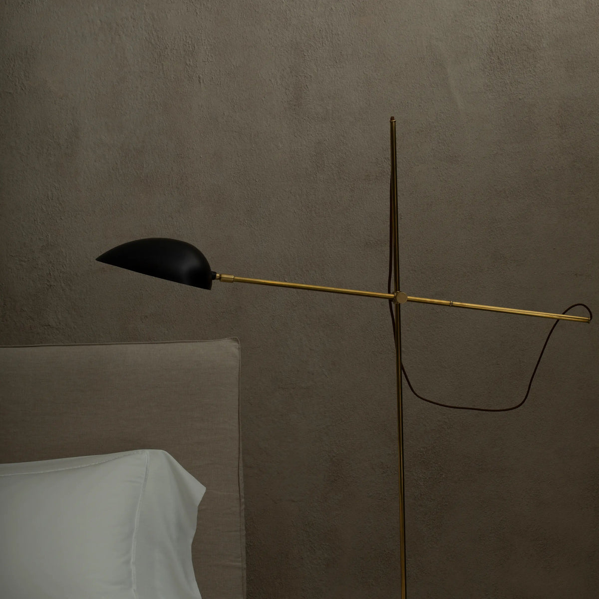 A minimalist floor lamp with an adjustable arm and exposed wire for a contemporary feel.