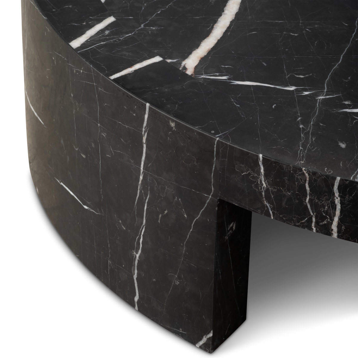 Close-up showing the corner of the Shift Coffee Table in Black Nero Marquina marble, with the honed top, a thick white vein, and one arched leg meeting the rim.