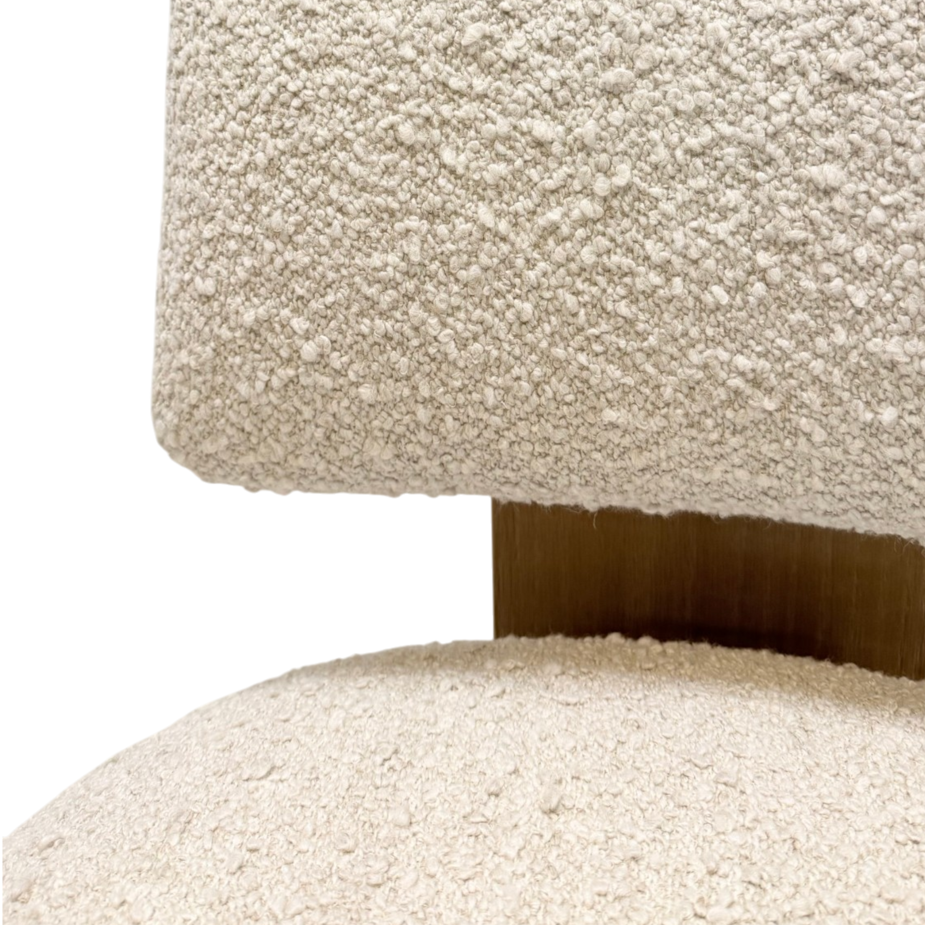 Close-up of a textured bouclé upholstered chair in warm off-white, showing the seat cushion and part of the backrest with a dark wood vertical support against a white background.