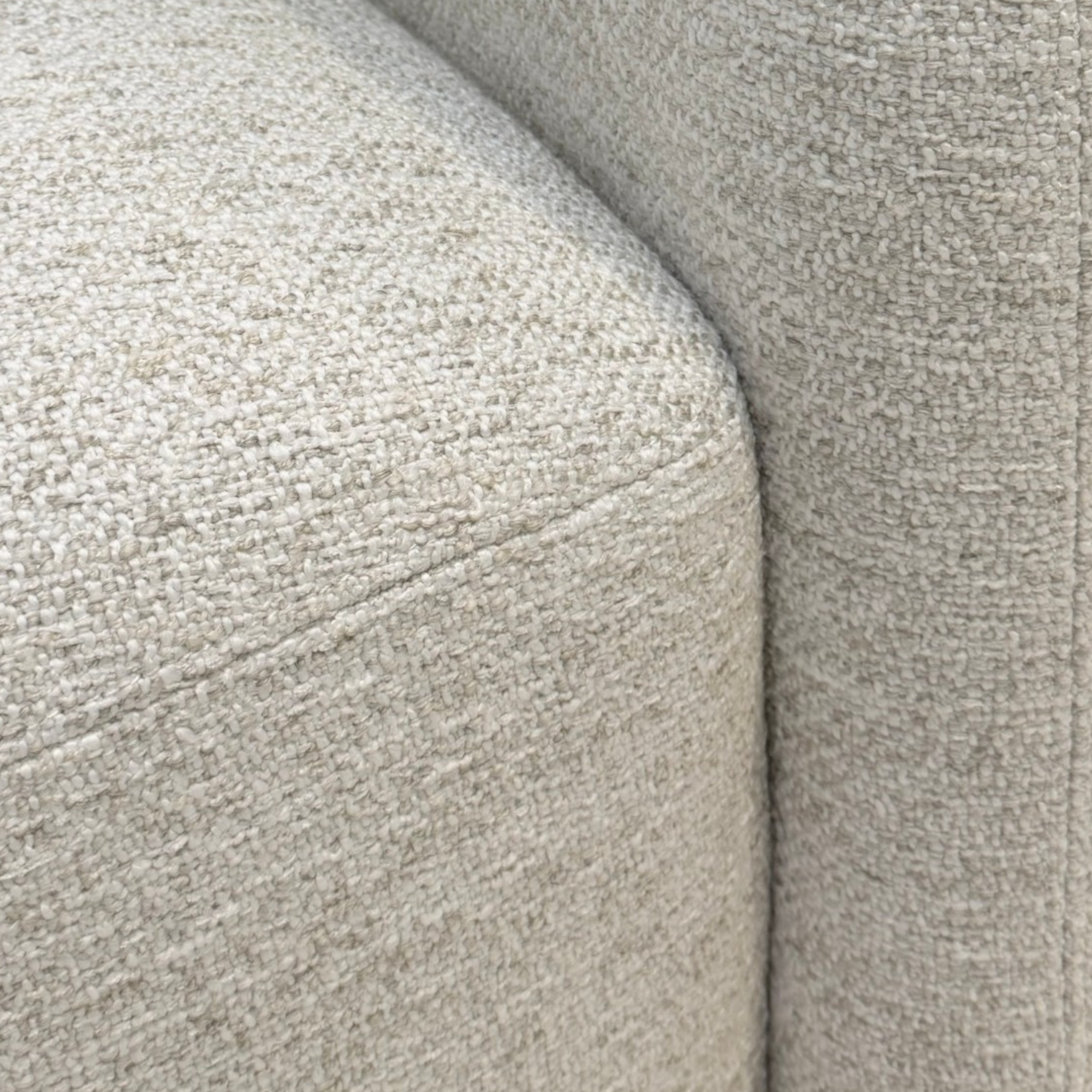 Detail view of Sigma Lounge Chair showing the rounded seat edge, curved arm and textured Grey Oak upholstery.