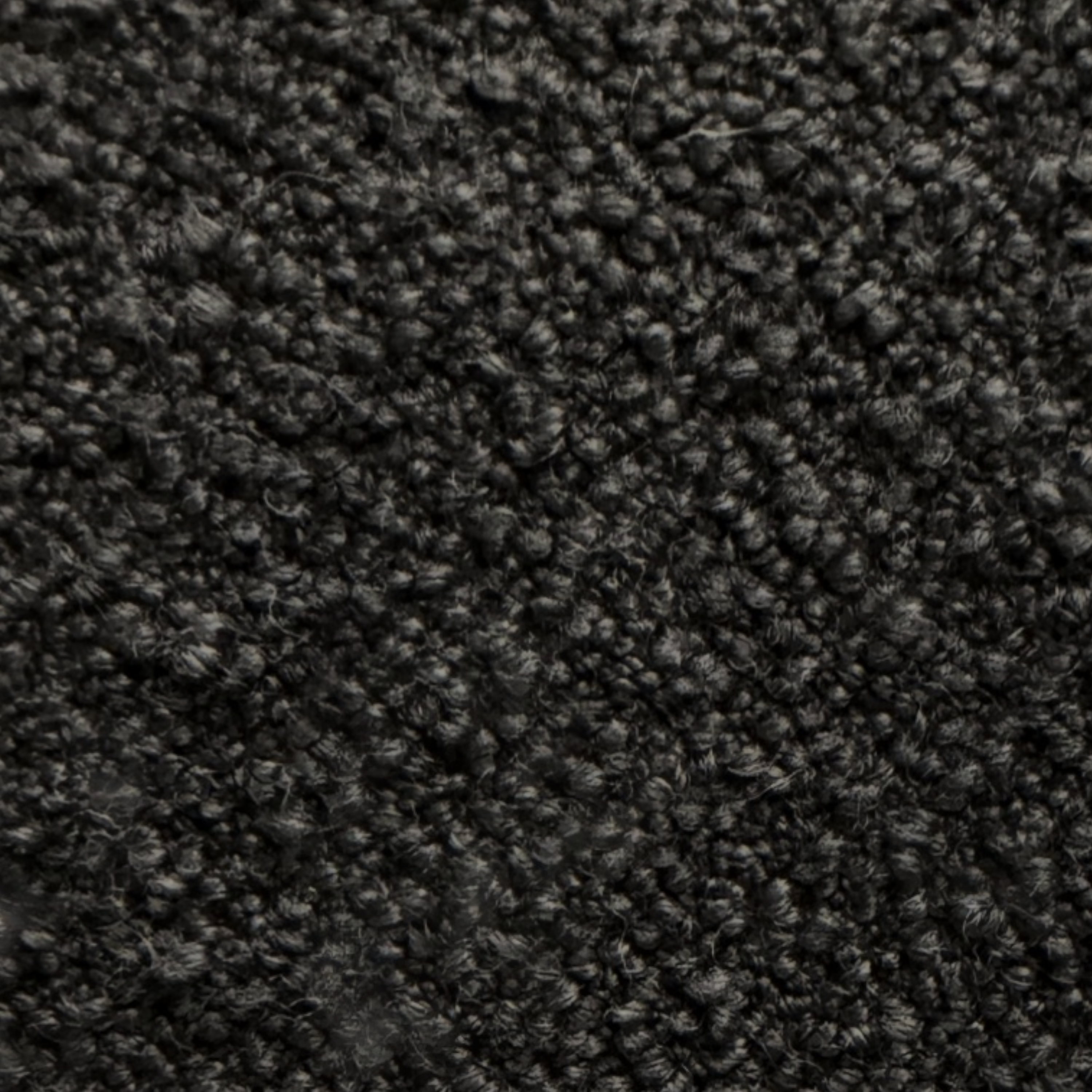 Detail view of the Arcus Swivel Chair upholstery showing the deep charcoal boucle-like textured fabric.