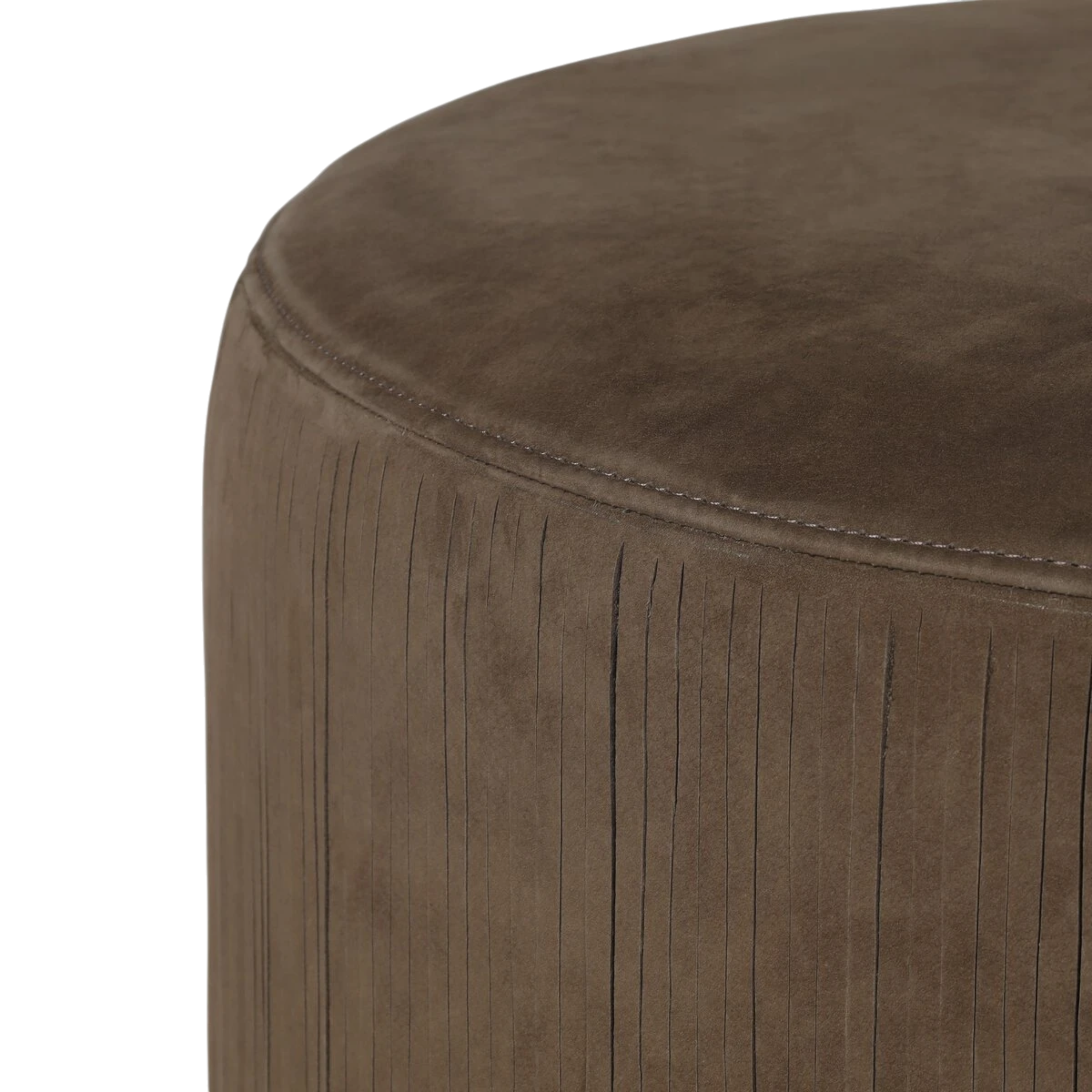 Close-up of a round upholstered Bauer Ottoman or stool in a taupe-brown suede-like fabric with vertical fringe around the sides, shown against a plain white background.