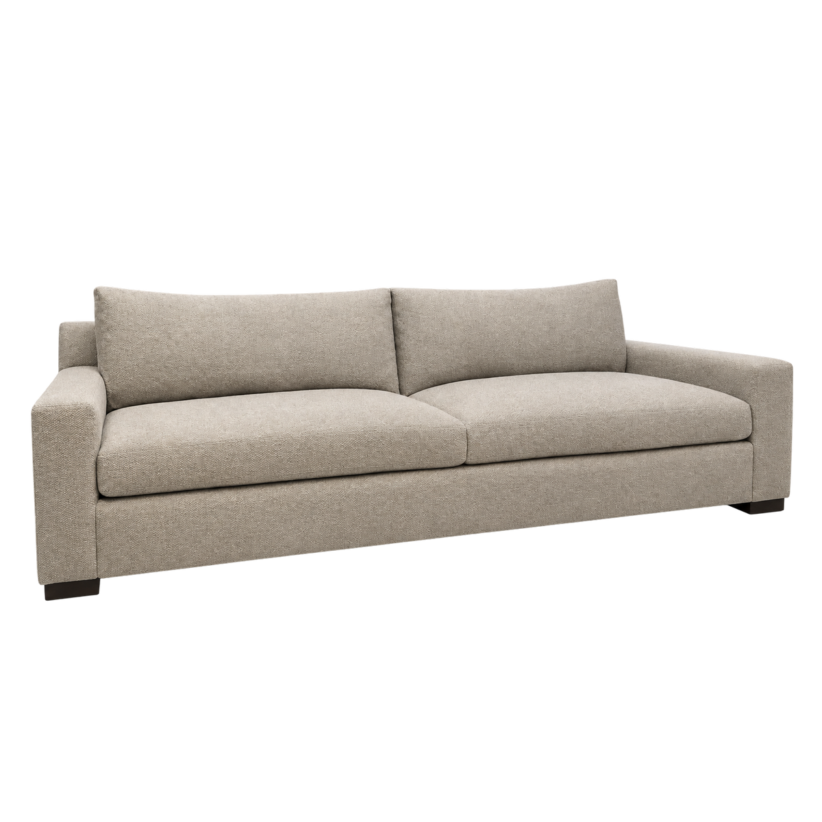 Solano Sofa angled view highlighting the long boxed base in heathered taupe upholstery, with thick seat cushions, loose back cushions and dark block feet.