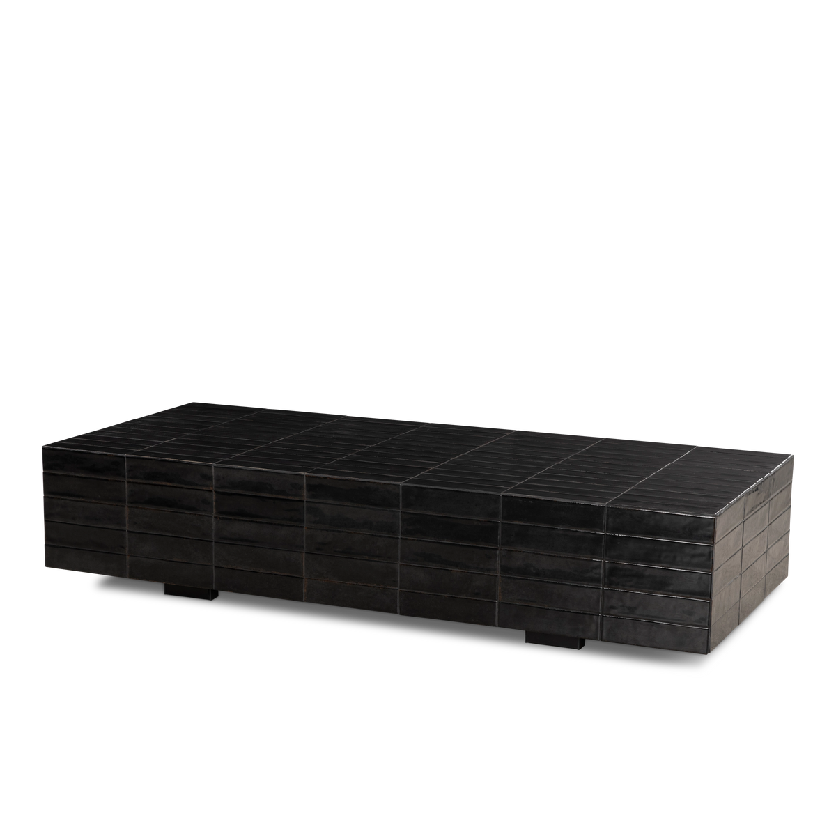 Bloor Coffee Table shown at an angle in Black glazed tile, highlighting the long tiled top, stacked tile sides, and two dark block feet underneath.