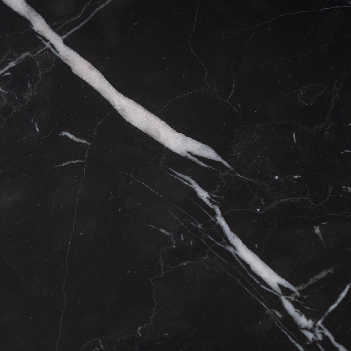 Shift Console Table close-up showing black Nero Marquina marble with a bold white vein and fine tracery across a honed surface.