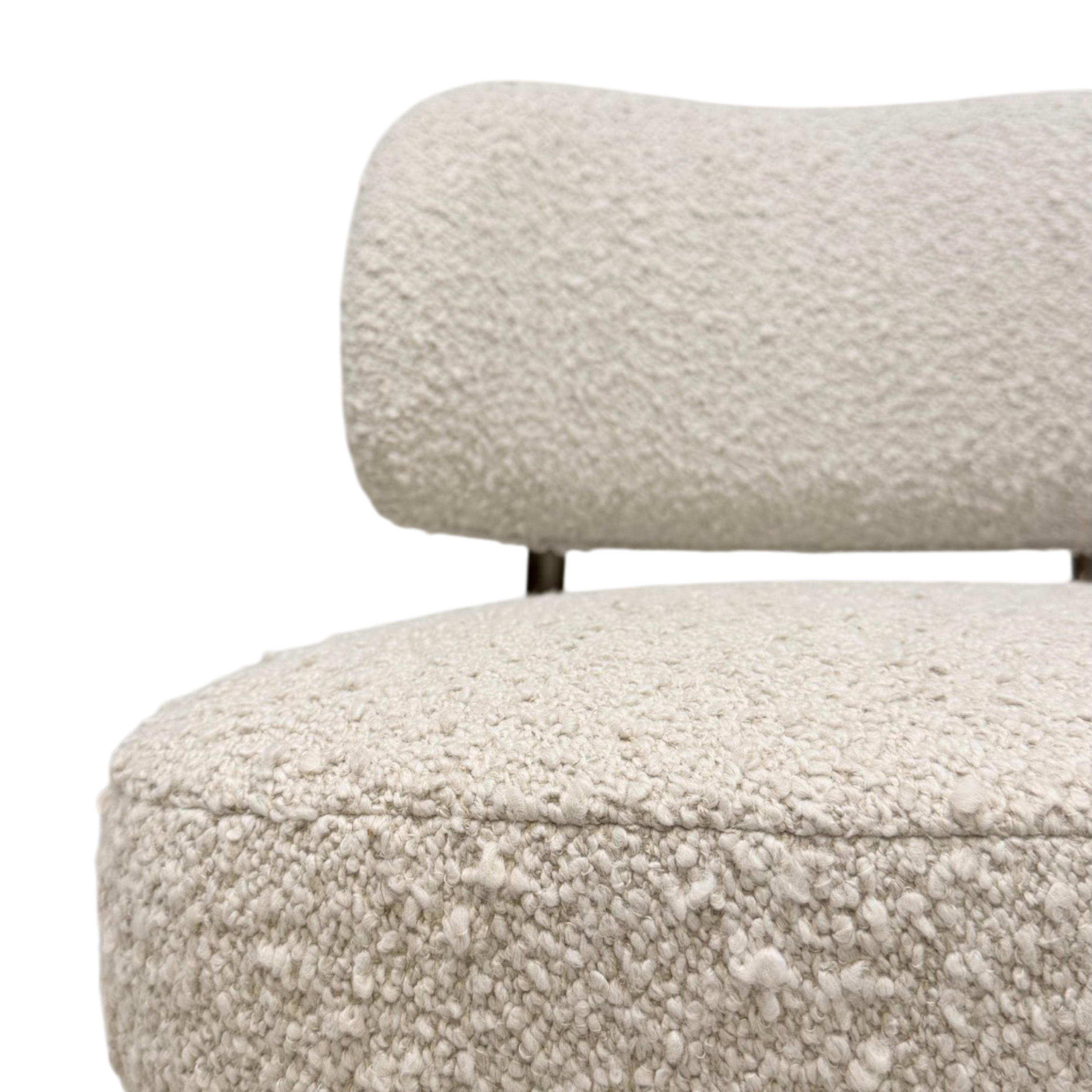 Close-up of a textured boucle upholstered chair with a rounded backrest and seat, shown against a plain white background.