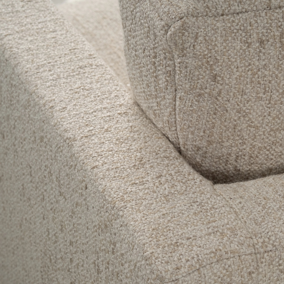Close-up showing the arm and back cushion of the Kore Taper Arm Sofa in Oatmeal textured fabric, with a stitched cushion edge and a flecked weave.