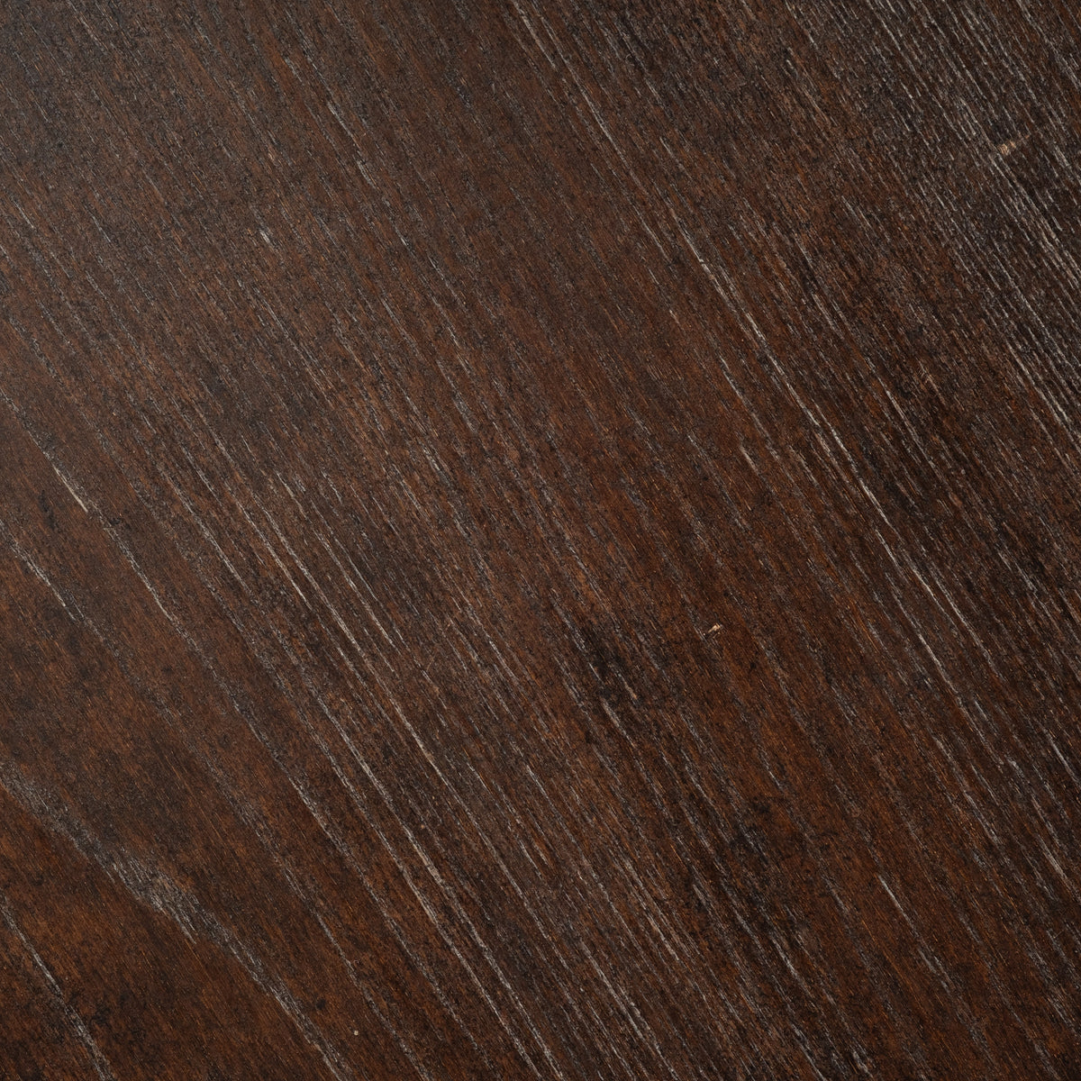 Close-up of the Calloway Side Table’s dark brown elm surface, showing diagonal grain with reddish-brown tones and fine lighter streaks.