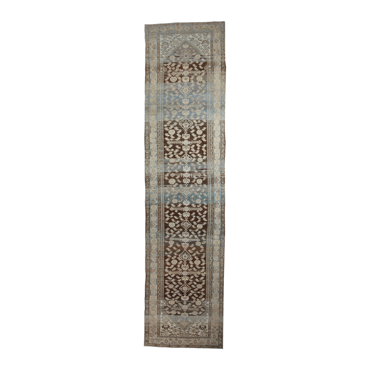 A long, narrow runner rug with an intricate traditional pattern in shades of brown, beige, light blue, and gray, shown flat against a solid white background.